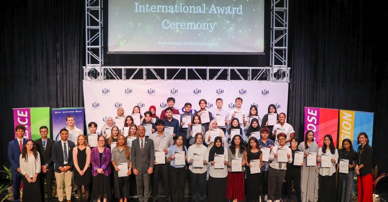 ISB students awarded Gold, Silver, and Bronze Duke of Edinburgh International Awards pose with Dr. Peter Jones, Head of ISB Secondary, along with teachers and staff, during the DofE International Award Ceremony at the ISB Theatre on April 15, 2025.